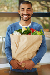 Man, portrait and grocery shopping in kitchen with vegetables and healthy food at home. Happy...