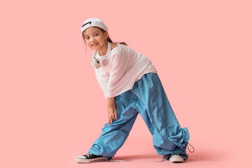 Cool little Asian girl in adult clothes on pink background