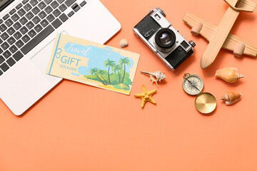 Composition with travel gift voucher, modern laptop, photo camera and wooden plane on color...