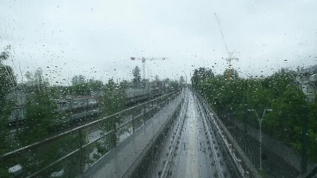 Canada British Columbia Vancouver view from the Sky Train window on a rainy day it is raining drops on the glass road from Surrey to the center of the embankment in Vancouver