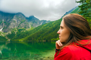 Beautiful Woman in Red Jacket Enjoying Scenic Mountain Lake View in Zakopane, Poland 