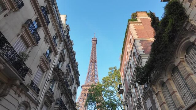 Image of Paris and the Eiffel Tower between buildings, unique point of view, city architecture. Capital of the 2024 Olympics. Paris 2024 Olympic Games.