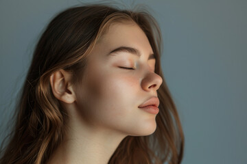 Fototapeta premium A close up of a woman's face with her eyes closed looking to a side