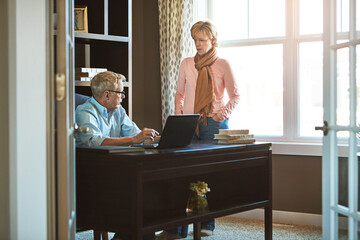Laptop, home office and senior couple with conversation for budget, savings and investment or...