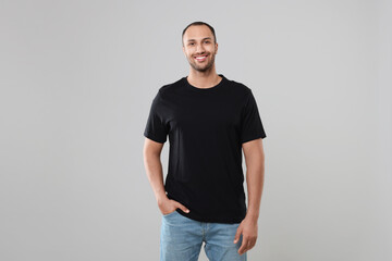 Man wearing black t-shirt on gray background