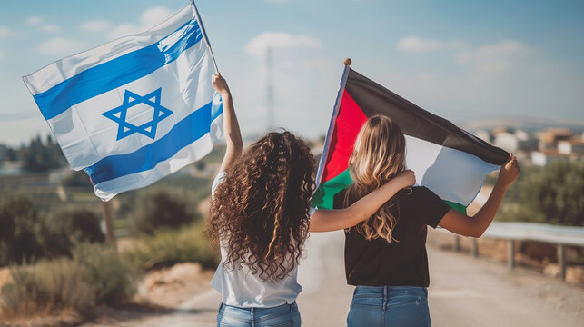 Two female friends walk together, one waving an israeli flag, the other a palestinian flag, symbolizing hope for peace and unity