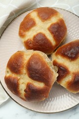 Hot cross buns on white marble table, top view