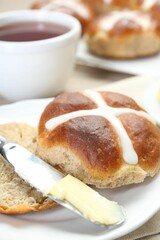 Tasty hot cross bun served on table, closeup