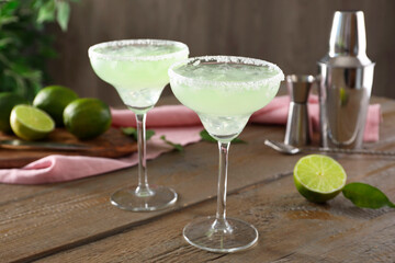 Delicious Margarita cocktail in glasses on wooden table, closeup