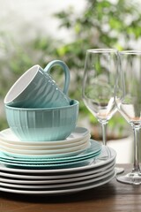 Beautiful ceramic dishware, glasses, cutlery and cup on wooden table outdoors