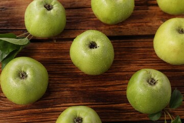 Fresh ripe green apples with water drops on wooden table
