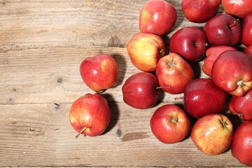 Many fresh apples with water drops on wooden table, top view. Space for text