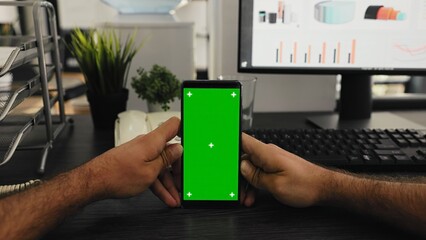 POV of manager holds smartphone with isolated greenscreen layout, working with blank mockup...