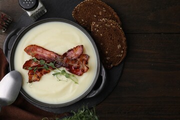 Delicious potato soup with bacon and microgreens in bowl served on wooden table, flat lay. Space for text
