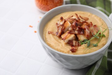 Delicious lentil soup with bacon and croutons on white tiled table, closeup. Space for text