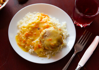 Ukrainian homemade meat tefteli served with rice and sauce on a plate in a cafe