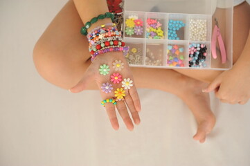 mãos de menina com miçangas para pulceiras infantis coloridas fofas 