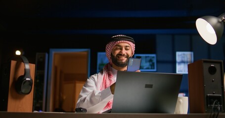 Arabic man checking up on abroad living friend during video conference meeting over the internet....