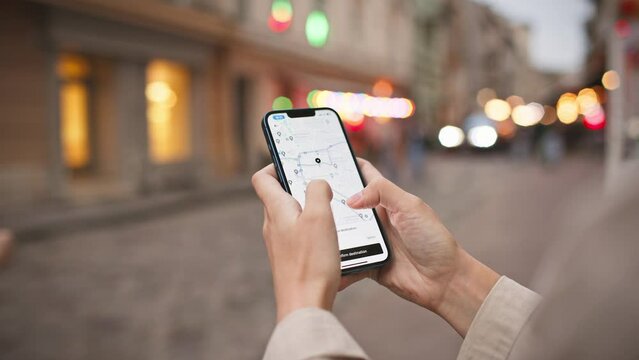 Woman standing in middle of street while using phone. Map visible on screen. Finding right path with digital gadget. Navigation search in app. Concept of location. GPS coordinates.