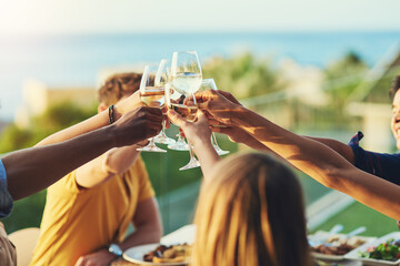 Wine, friends and hands toast together by table for celebration, tradition and outdoor reunion for...