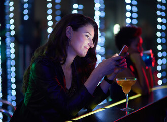 Happy, woman and cocktail in night club with cellphone at event, disco or concert for drink at bar....