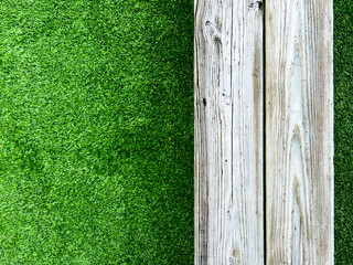 Empty wooden bench sits on top of a green turf football or soccer field. Overhead view with room for copy space.