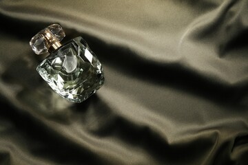 Luxury perfume in bottle on dark silk fabric, top view © New Africa