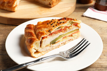 Piece of tasty homemade pie with filling served on wooden table