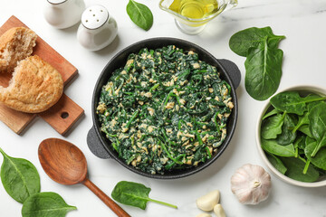 Tasty spinach dip with eggs in dish served on white table, flat lay