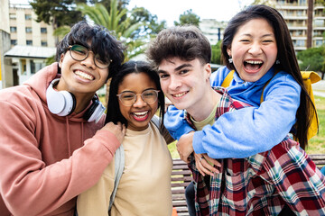 Cheerful multiracial group of young students friends smiling at camera while standing outdoors at...