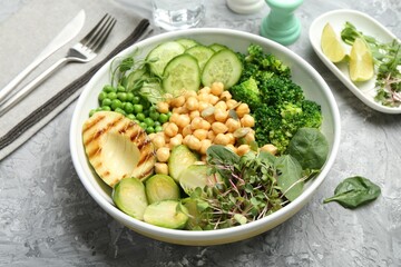 Healthy meal. Tasty vegetables and chickpeas in bowl on grey table