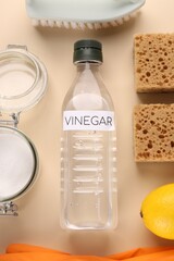 Eco friendly natural cleaners. Flat lay composition with bottle of vinegar on beige background