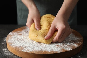 Making shortcrust pastry. Woman kneading dough at table, closeup