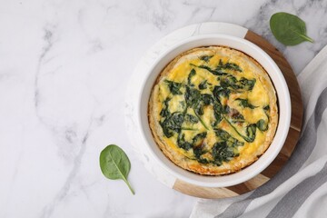 Delicious pie with spinach on white marble table, flat lay. Space for text