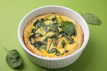 Delicious pie with spinach on green background, closeup