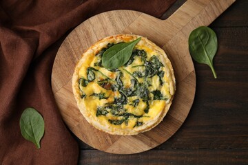 Delicious pie with spinach on wooden table, top view