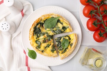 Delicious pie with spinach on white tiled table, flat lay