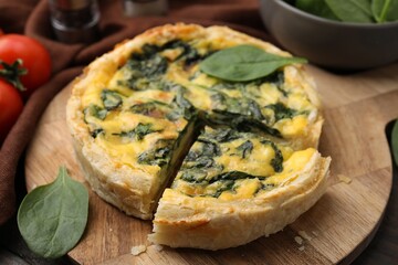 Delicious pie with spinach on table, closeup
