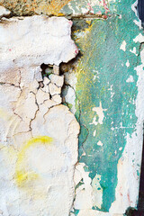 Cracked faded plaster green yellow white obsolete wall texture, background