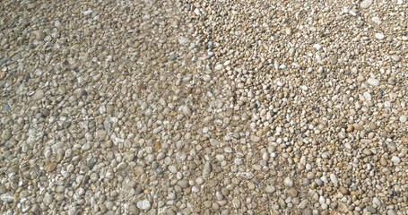 CLOSE UP, TOP DOWN: Pebbly coast on Hvar island lapped by crystal clear sea water. A peaceful summer view from sunlit Adriatic beach, when the sea gently flows over scattered white round stones.