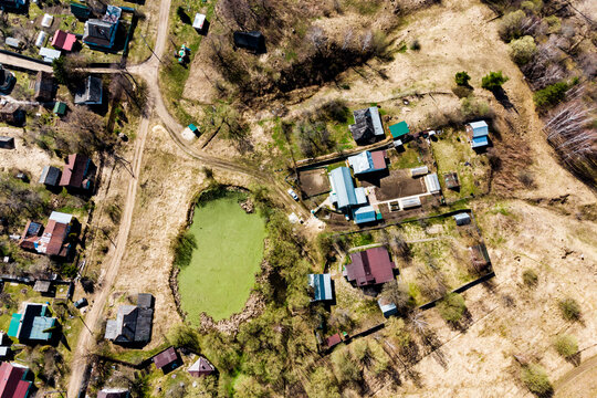Aerial view of village buildings and a green pond. Kaluga region, Russia - Powered by Adobe