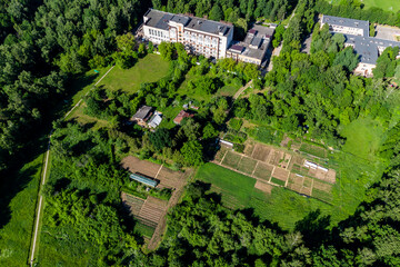 Fototapeta premium Aerial view of vegetable gardens and village buildings adjacent to city buildings