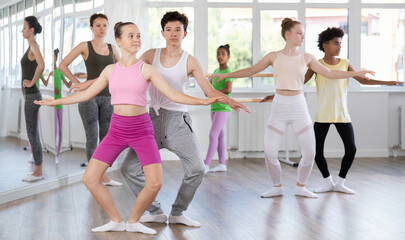 Obraz premium Teenage boy and teenage girl dancers rehearsing pair ballet in studio