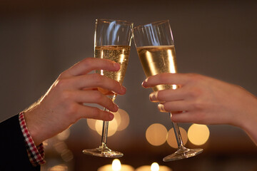 Couple, wine glasses and toast on celebration date or romantic night together for bonding, love and relationship. People, hands and cups with alcohol in restaurant for memories, dinner or anniversary