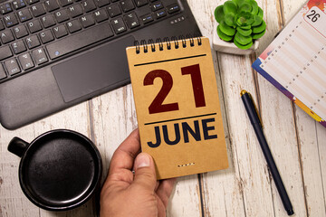 June 21 calendar date text on wooden blocks with blurred nature background.