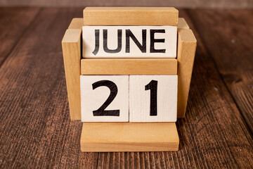 June 21 calendar date text on wooden blocks with blurred nature background.