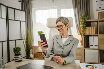 One mature woman take a break from work buy online with credit card