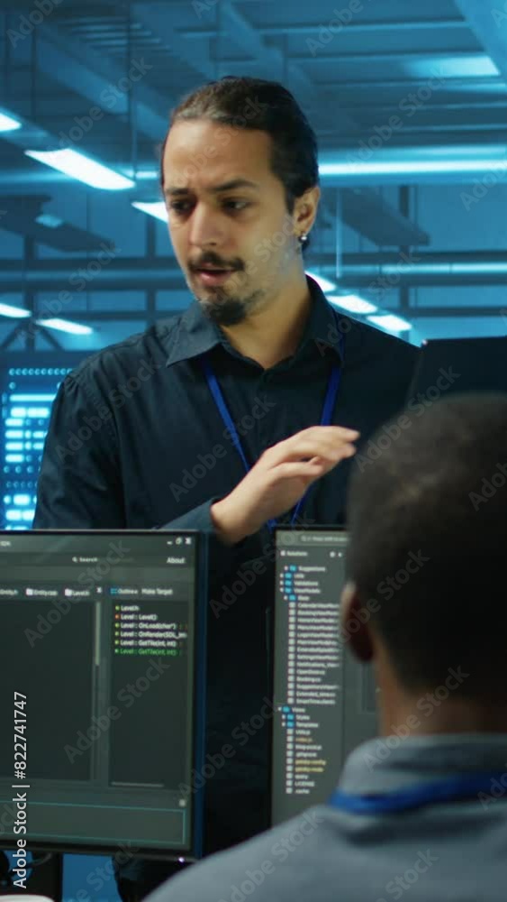 Poster vertical video manager supervising multiethnic team working in data center ensuring optimal performa
