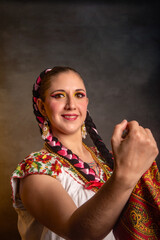 Mexican woman with Mexican warrior state costume A woman with long black hair and a red and white dress is smiling