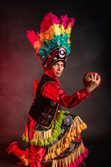 Matlachines Dancer from Coahuila Mexico A man in a colorful costume is holding a red ball